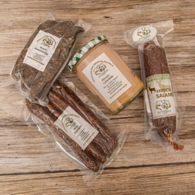 Verschiedene Wurstwaren in Verpackungen, darunter Salami und andere Fleischprodukte.