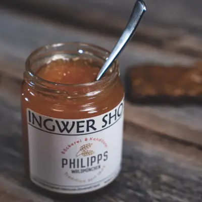Ein Glas Ingwer Shot mit einem Löffel, beschriftet mit Philipps Bäckerei und Konditorei.