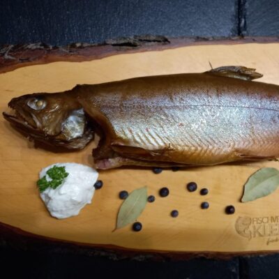 Frischer Saibling auf Holzbrett und Garnitur mit Frischkäse