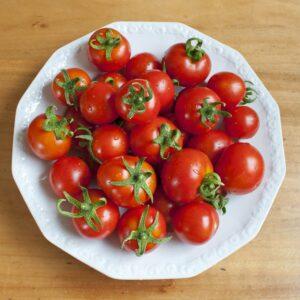 Viele frische Tomaten auf weißem Teller