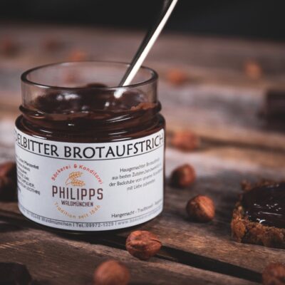 Edelbitteraufstrich im Glas auf frischem Brot