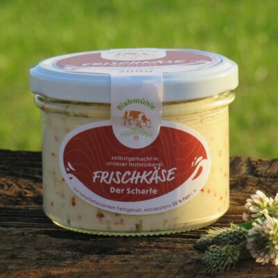 Frischkäse "Der Scharfe" im Glas auf Holzbrett