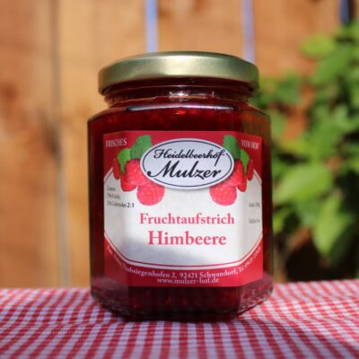 Fruchtaufstrich im Glas auf Tischdecke