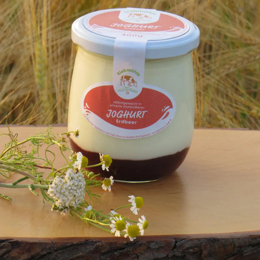 Fruchtjoghurt Erdbeere im Schraubglas auf Holzbrett