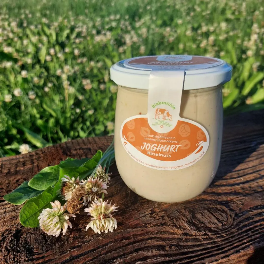 Joghurt Haselnuss auf Holzbrett und Blumenwiese