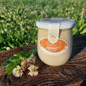 Joghurt Haselnuss auf Holzbrett und Blumenwiese