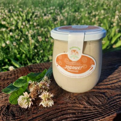 Joghurt Haselnuss auf Holzbrett und Blumenwiese
