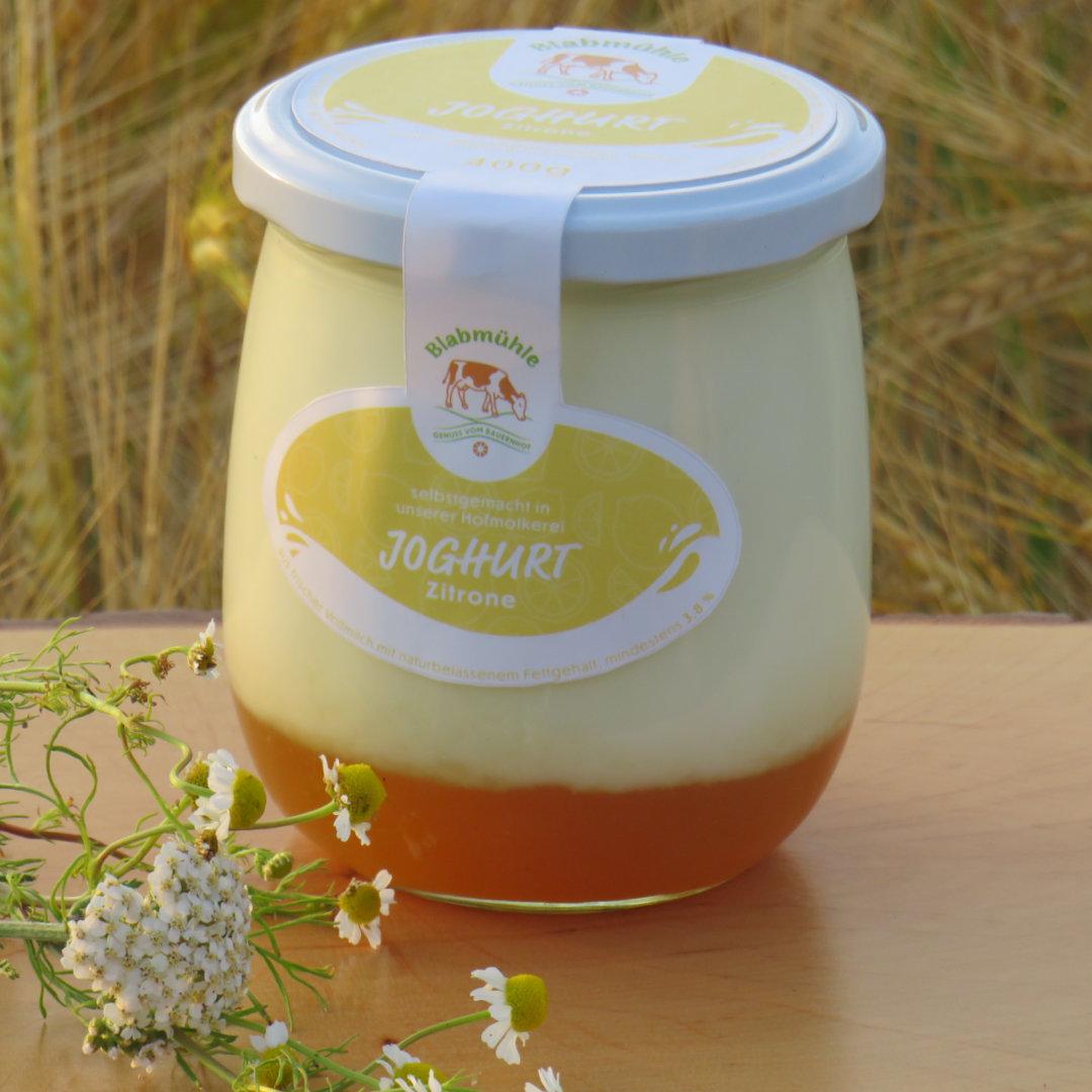 Joghurt Zitrone im Schraubglas auf Holzbrett im Hintergrund Hanf