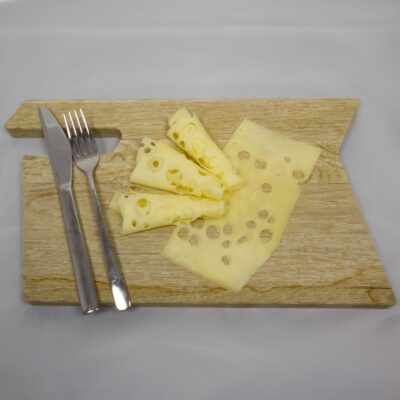 Käseaufschnitt auf Holzbrett mit Silberbesteck