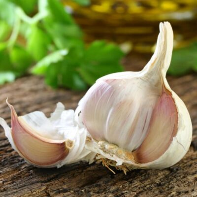 Frischer Knoblauch aufgeschnitten auf Holzbrett