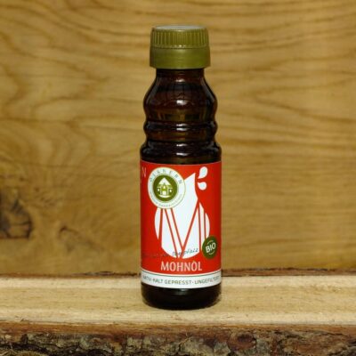 Mohnöl in Glasflasche auf Holzbrett