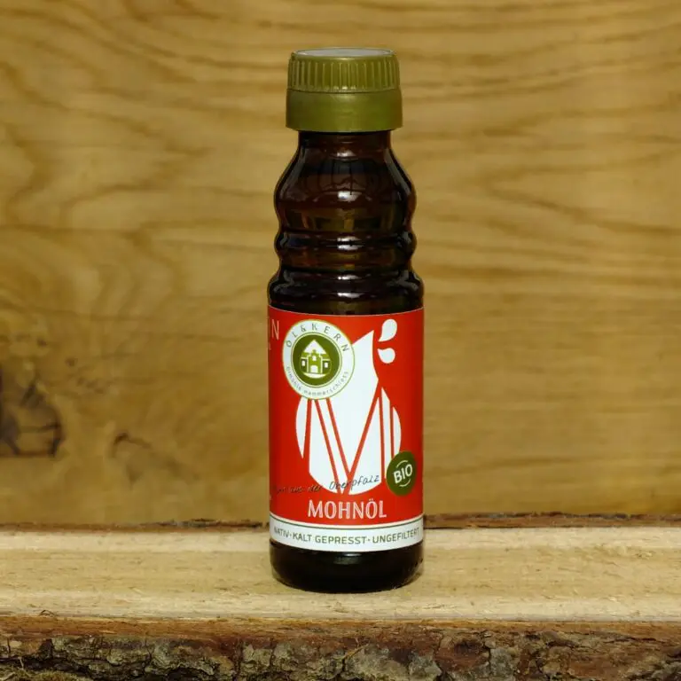 Mohnöl in Glasflasche auf Holzbrett