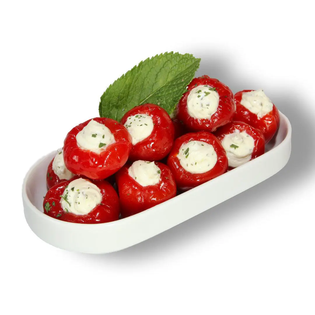 Gefüllte Paprika mit Frischkäse Frische Paprini gefüllt in Servierschale auf Minzegarnitur