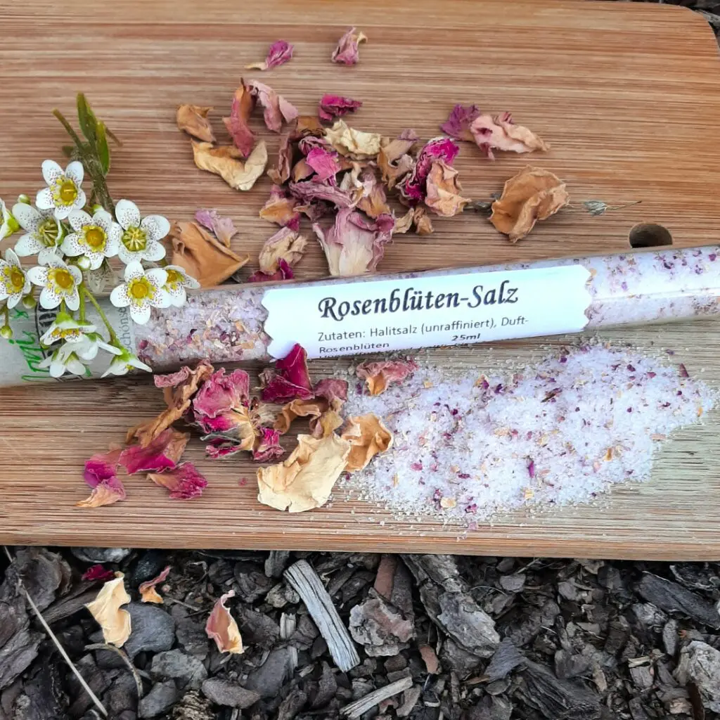 Rosenblütensalz im Glas auf getrockneten Rosen
