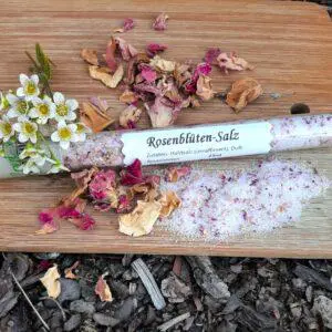 Rosenblütensalz im Glas auf getrockneten Rosen