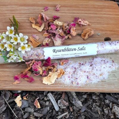 Rosenblütensalz im Glas auf getrockneten Rosen