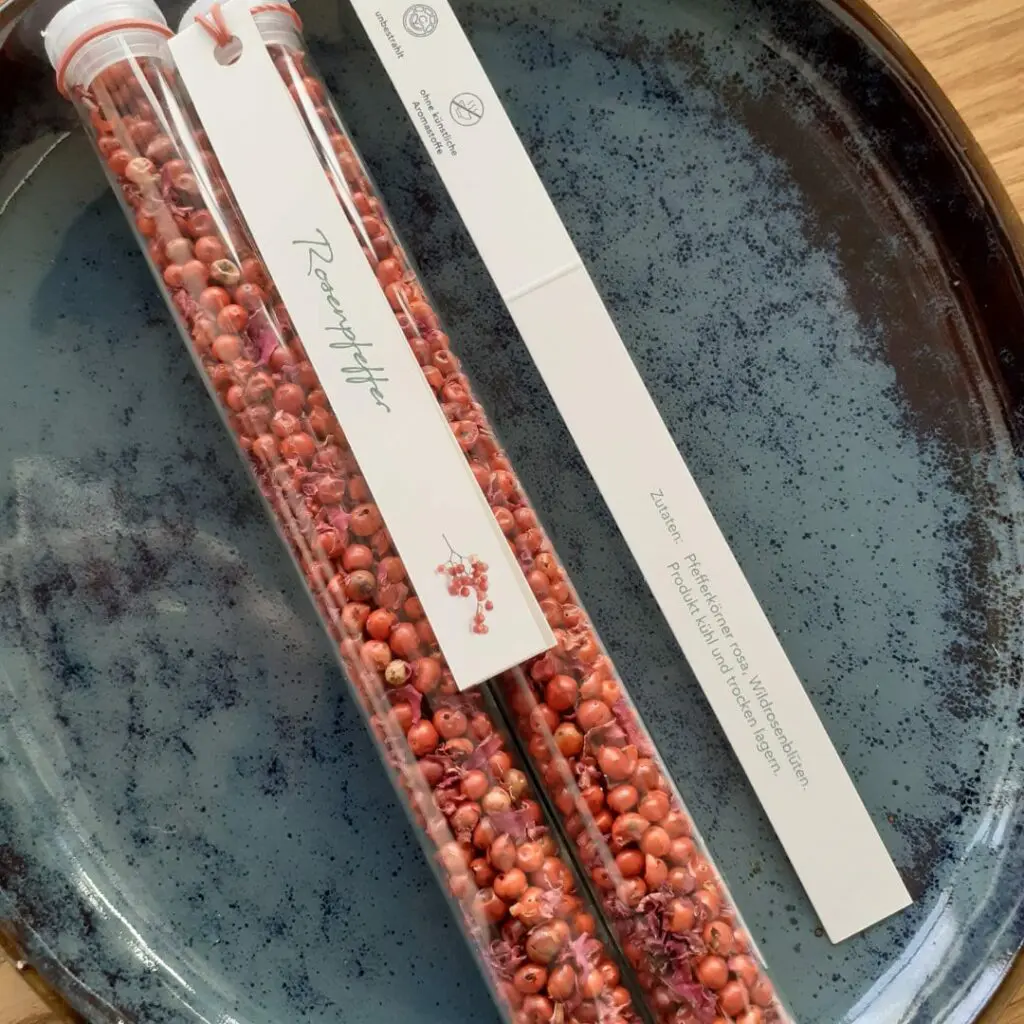 Rosenpfeffer im Glas auf Porzelanschüssel