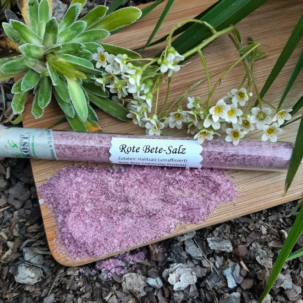 Rote Bete Salz im Glas auf Holzbrett und Blumendeko