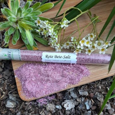 Rote Bete Salz im Glas auf Holzbrett und Blumendeko