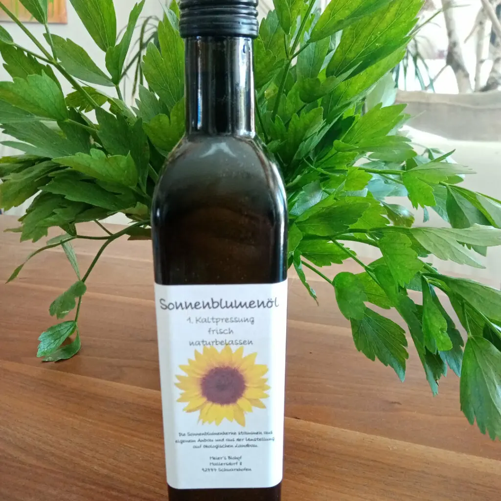 Sonnenblumenöl in Glasflasche auf frischer Petersilie
