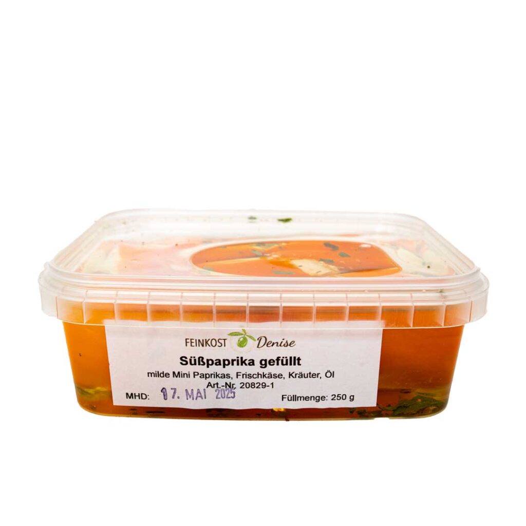 Eine transparente Frischhaltebox mit gefüllten Süßpaprika, beschriftet mit 'Feinkost Denise'.