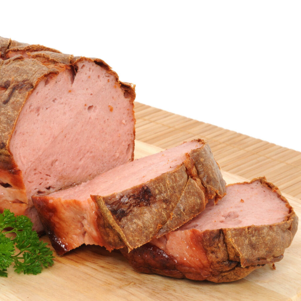 Dicker Leberkäse in Scheiben auf Holzbrett