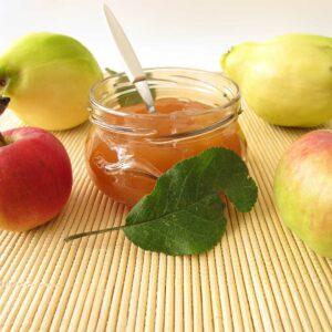 Frischer Fruchtaufstrich Apfel-Quitte im Glas mit roten Äpfeln