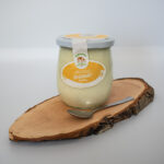 Joghurt Vanille mit Löffel auf einem Holzbrett