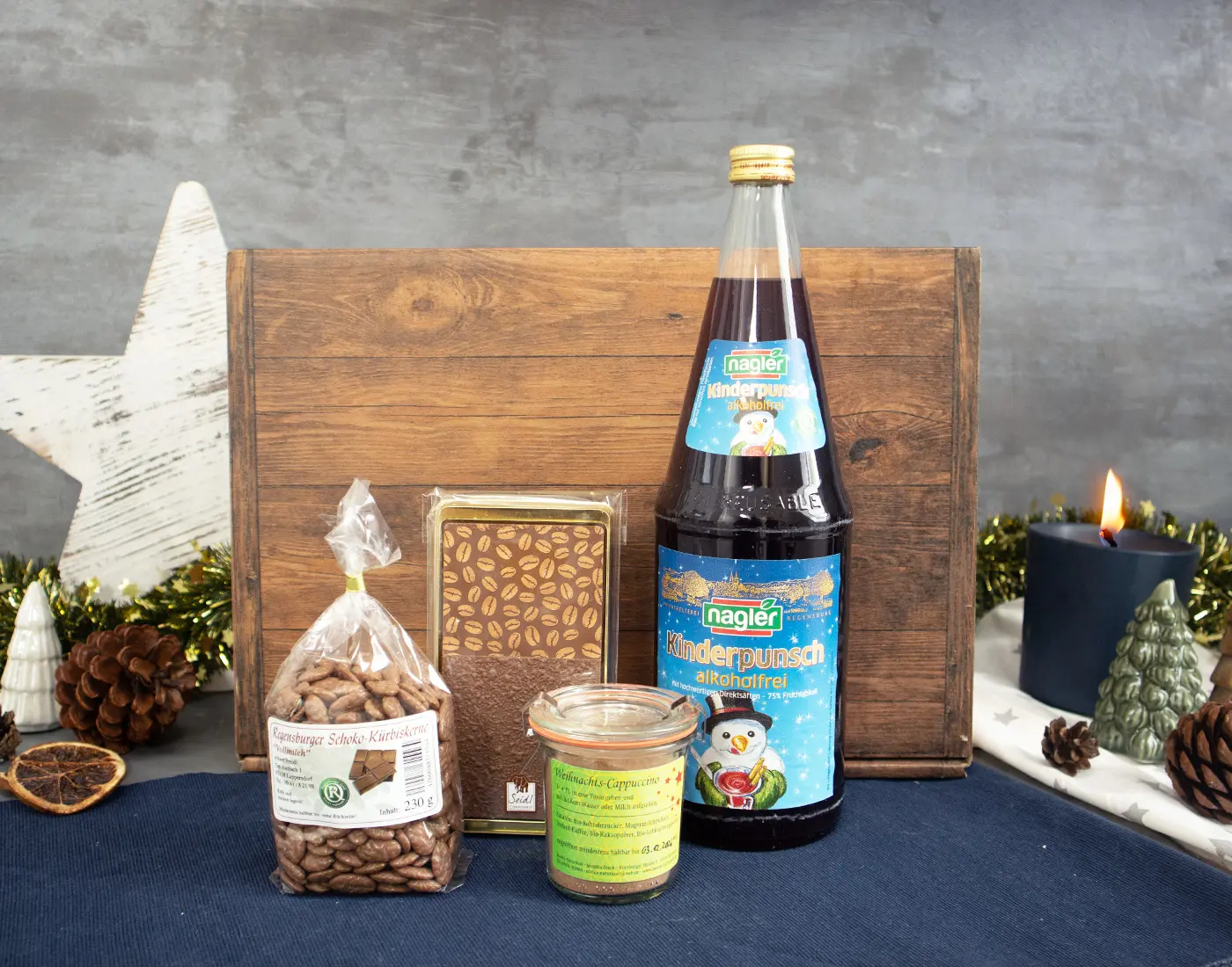 Flasche Naegler Kinderpunsch, Weihnachtsgebäck und Gewürze auf einem Holzuntergrund.
