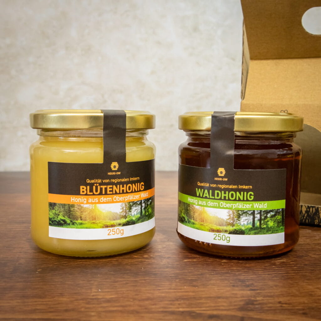 Honig Geschenkset mit Blütenhonig und Waldhonig aus der Oberpfalz in dekorativer Kartonverpackung mit gelber Schleife und Honigheber