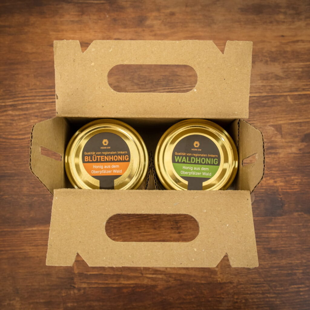 Honig Geschenkset mit Blütenhonig und Waldhonig aus der Oberpfalz in dekorativer Kartonverpackung mit gelber Schleife und Honigheber